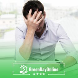 A man sitting at a desk with his head in his hands trying to block a payday lender from debiting their account