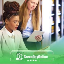 Two women sitting at a table reading about payday loan fees on a tablet