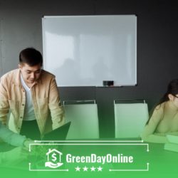 A group of people sitting at a table with laptops searching for Indianapolis payday loans